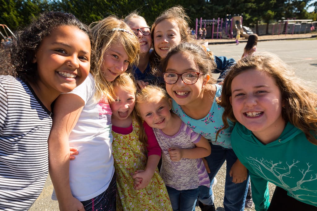 Smiling children gathered on a playground in Anacortes. They are depending on the voters in to vote YES on the upcoming Anacortes school levies to make up for what the state and federal funding does not cover.