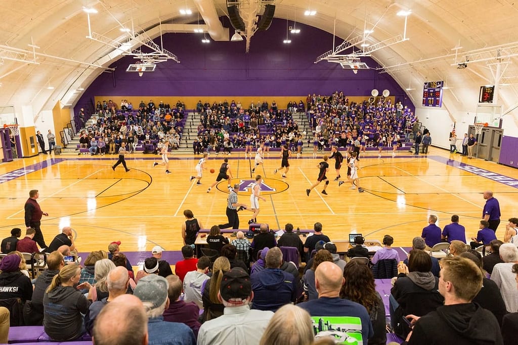 Inside the Anacortes High School gym, students play basketball while parents watch. The upcoming Anacortes School levies will provide funding to maintain our high quality extra-curricular programs, including athletics, music and arts.